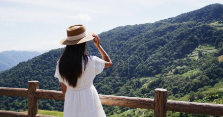Téléchargez les photos : Femme debout sur la terrasse et regarder la montagne - en image libre de droit