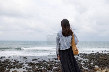 Foto de Mujer mira el mar en el mal tiempo - Imagen libre de derechos