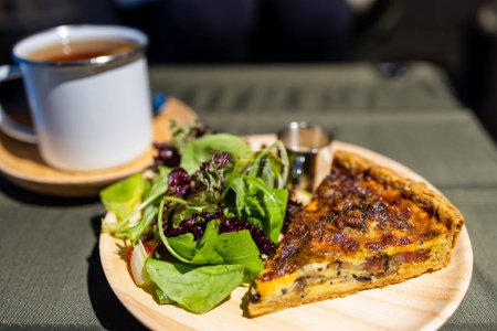 Téléchargez les photos : Tranche de tarte au poulet et champignons avec salade sur le plat dans le café - en image libre de droit