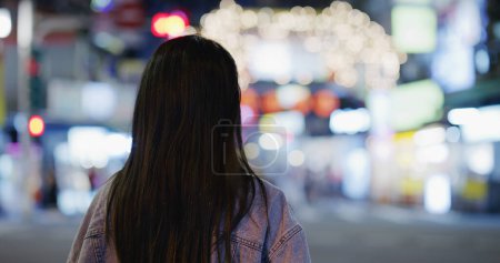 Foto de Vista trasera trasera de la mujer mira a la ciudad por la noche - Imagen libre de derechos