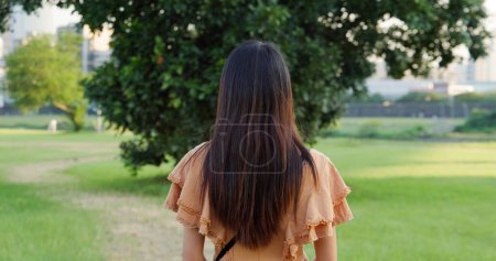 Téléchargez les photos : Back rear view of woman stand in front of the garden - en image libre de droit
