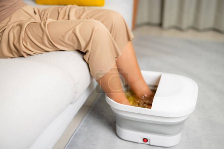 Téléchargez les photos : Femme faire bain de pieds elle-même à la maison - en image libre de droit