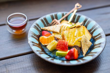 Téléchargez les photos : Toast au miel avec beaucoup de fruits au café extérieur - en image libre de droit