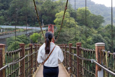 Téléchargez les photos : Woman stepping onto the suspension bridge in Wulai of Taiwan - en image libre de droit