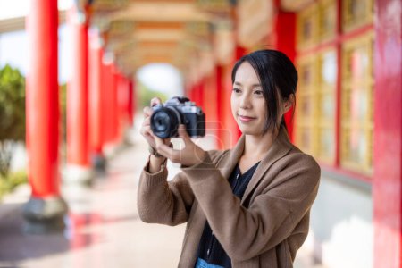 Téléchargez les photos : Travel woman use digital camera to take photo in Chinese temple - en image libre de droit