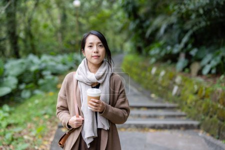 Téléchargez les photos : Femme tenir avec une tasse de café sur fond de randonnée - en image libre de droit