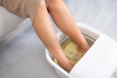 Femme profiter bain de pieds à la maison