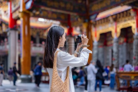 Foto de Mujer utilizar la cámara digital para tomar la foto en el templo chino - Imagen libre de derechos