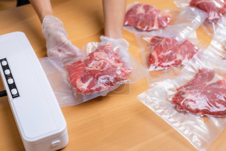 Téléchargez les photos : Viande de bœuf crue scellée dans une pellicule plastique rétractable avec scellant sous vide - en image libre de droit