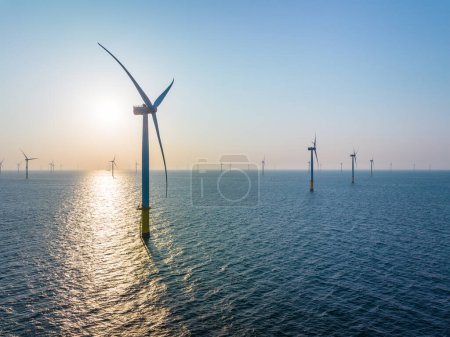 Téléchargez les photos : Champ d'éoliennes au-dessus de la mer le soir - en image libre de droit