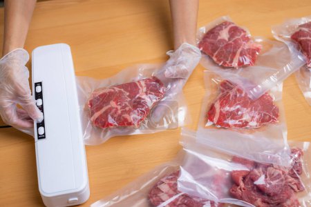 Photo for Raw beef meat sealed in plastic shrink wrap with vacuum sealer - Royalty Free Image