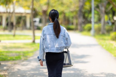 Téléchargez les photos : Une femme marche dans le parc - en image libre de droit