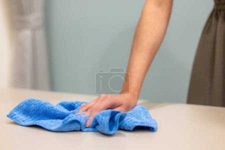 Téléchargez les photos : Femme au foyer nettoyer la table avec chiffon - en image libre de droit