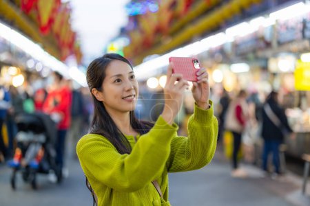 Foto de Mujer utilizar el teléfono celular para tomar una foto en el mercado de la calle Keelung de Taiwán - Imagen libre de derechos