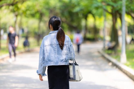 Téléchargez les photos : Femme profiter d'avoir une promenade dans le jardin - en image libre de droit