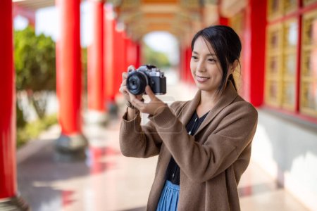 Foto de Travel woman use digital camera to take photo in Chinese temple - Imagen libre de derechos