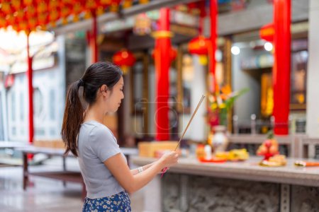 Téléchargez les photos : Femme prie avec de l'encens dans le temple chinois - en image libre de droit