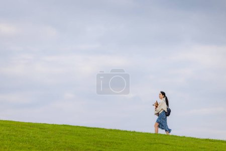 Foto de Mujer con su perro salchicha paseando por el parque - Imagen libre de derechos