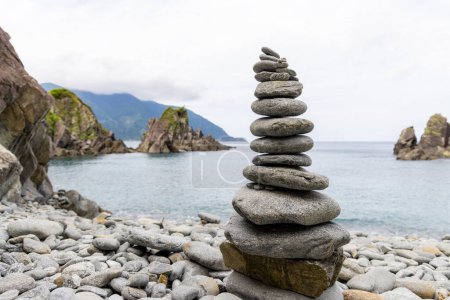 Téléchargez les photos : Pebble tower balance harmony stones arrangement on sea beach coastline - en image libre de droit