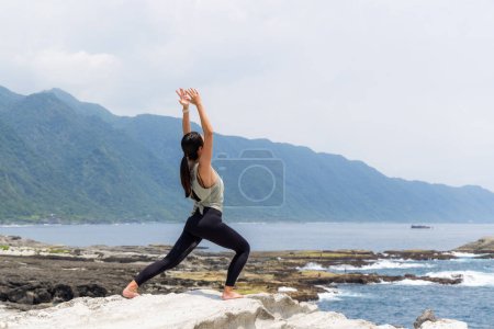 Téléchargez les photos : Femme pratiquant le yoga sur la plage - en image libre de droit