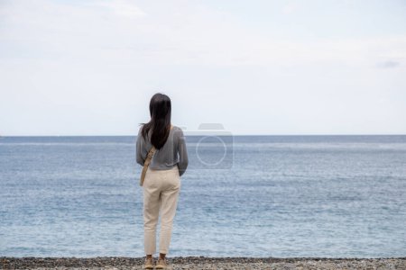 Photo for Woman stand beside the beach and enjoy the view - Royalty Free Image
