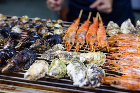Téléchargez les photos : Barbecue mixte de fruits de mer sur grill filet métallique - en image libre de droit