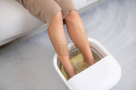 Téléchargez les photos : Femme faire bain de pieds elle-même à la maison - en image libre de droit