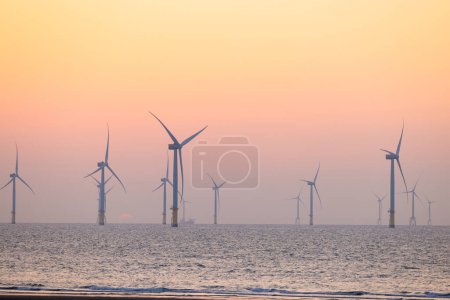 Téléchargez les photos : Champ d'éoliennes au-dessus de la mer le soir - en image libre de droit
