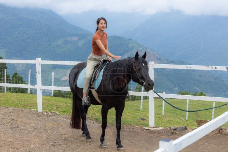 Foto de Mujer montar un caballo en la granja - Imagen libre de derechos