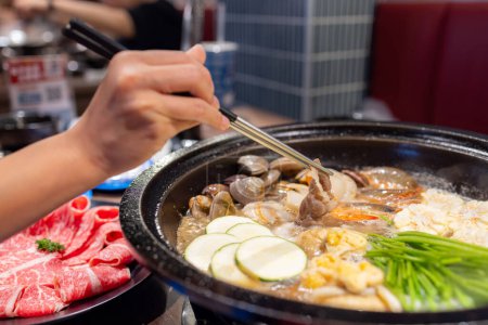 Téléchargez les photos : Hotpot avec tranche de viande fraîche et de la nourriture au restaurant - en image libre de droit
