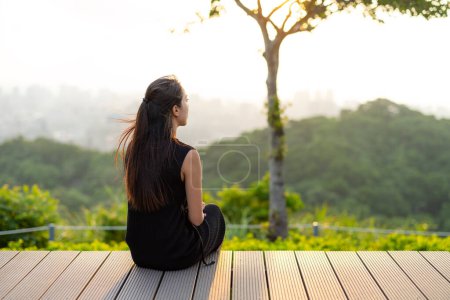 Foto de La mujer se sienta en la cubierta y mira el paisaje en la montaña - Imagen libre de derechos