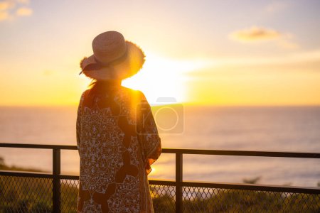 Foto de Mujer turística disfrutar de la puesta de sol vista al mar - Imagen libre de derechos