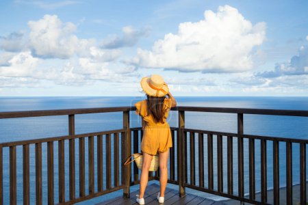 Téléchargez les photos : Femme regarder la mer dans une journée ensoleillée - en image libre de droit