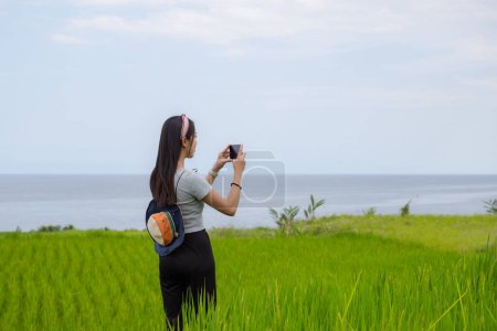 Foto de Turista mujer utilizar el teléfono celular para tomar fotos en el campo - Imagen libre de derechos