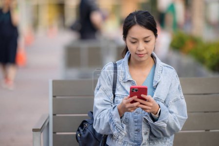 Téléchargez les photos : Femme utiliser un téléphone mobile et s'asseoir sur un café extérieur - en image libre de droit