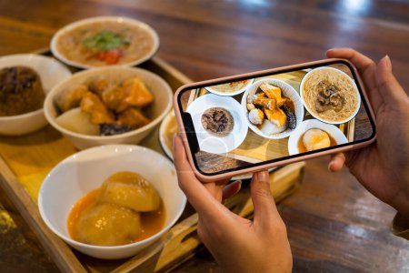 Téléchargez les photos : Utilisez votre téléphone portable pour prendre des photos sur la nourriture - en image libre de droit