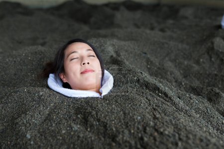 Photo for Woman enjoy hot sand bath - Royalty Free Image