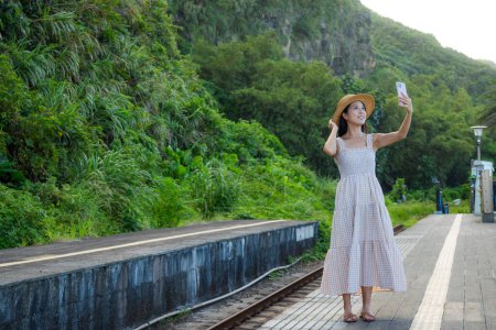 Photo for Woman take selfie on mobile phone in train platform - Royalty Free Image