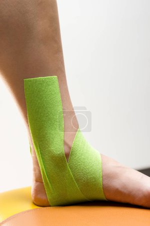 Photo for Elastic therapeutic tape on the foot - Royalty Free Image