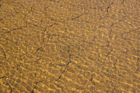 Foto de Río a través del suelo seco agrietado suelo - Imagen libre de derechos