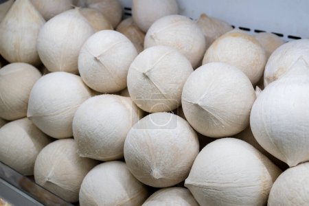 Téléchargez les photos : Jeune noix de coco crue fraîche vendue sur le marché humide - en image libre de droit