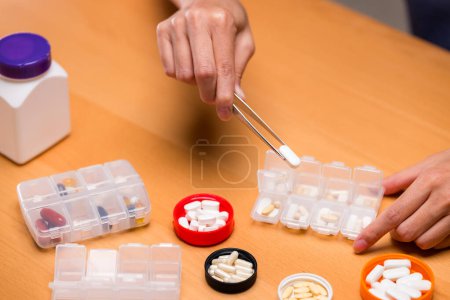 Téléchargez les photos : Mettez des médicaments sur la boîte à pilules médicales - en image libre de droit