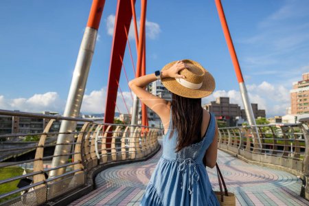 Téléchargez les photos : Voyage femme marcher le long du pont au jour ensoleillé - en image libre de droit