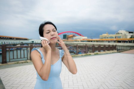 Photo for Woman use tissue for sweating at outdoor in city - Royalty Free Image