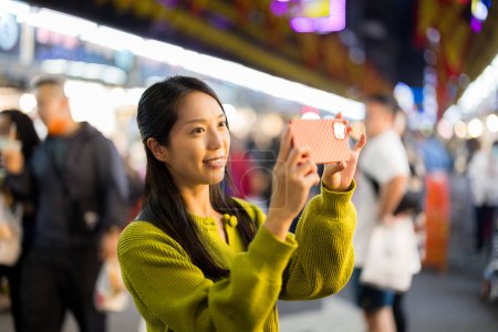 Foto de Mujer utilizar el teléfono celular para tomar fotos en el mercado callejero en Taiwán - Imagen libre de derechos