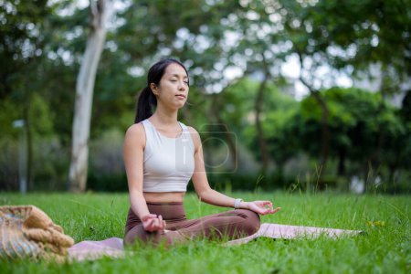 Téléchargez les photos : Femme faire de la méditation au parc - en image libre de droit