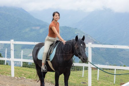 Foto de Mujer montar un caballo en la granja - Imagen libre de derechos