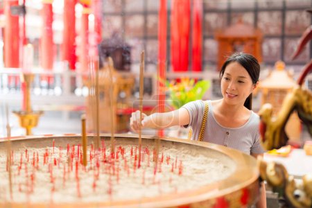 Foto de Mujer sosteniendo palos de incienso en el templo chino - Imagen libre de derechos