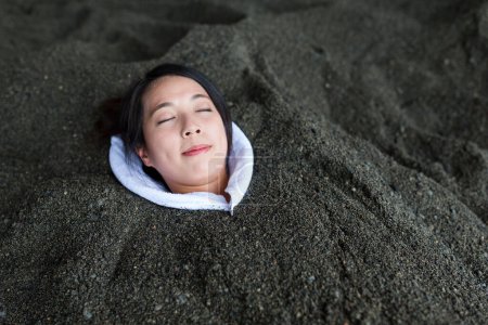 Photo for Woman enjoy hot sand bath - Royalty Free Image
