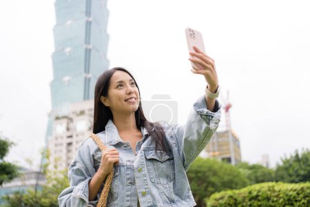 Téléchargez les photos : Femme prendre selfie sur téléphone portable dans la ville de Taipei - en image libre de droit